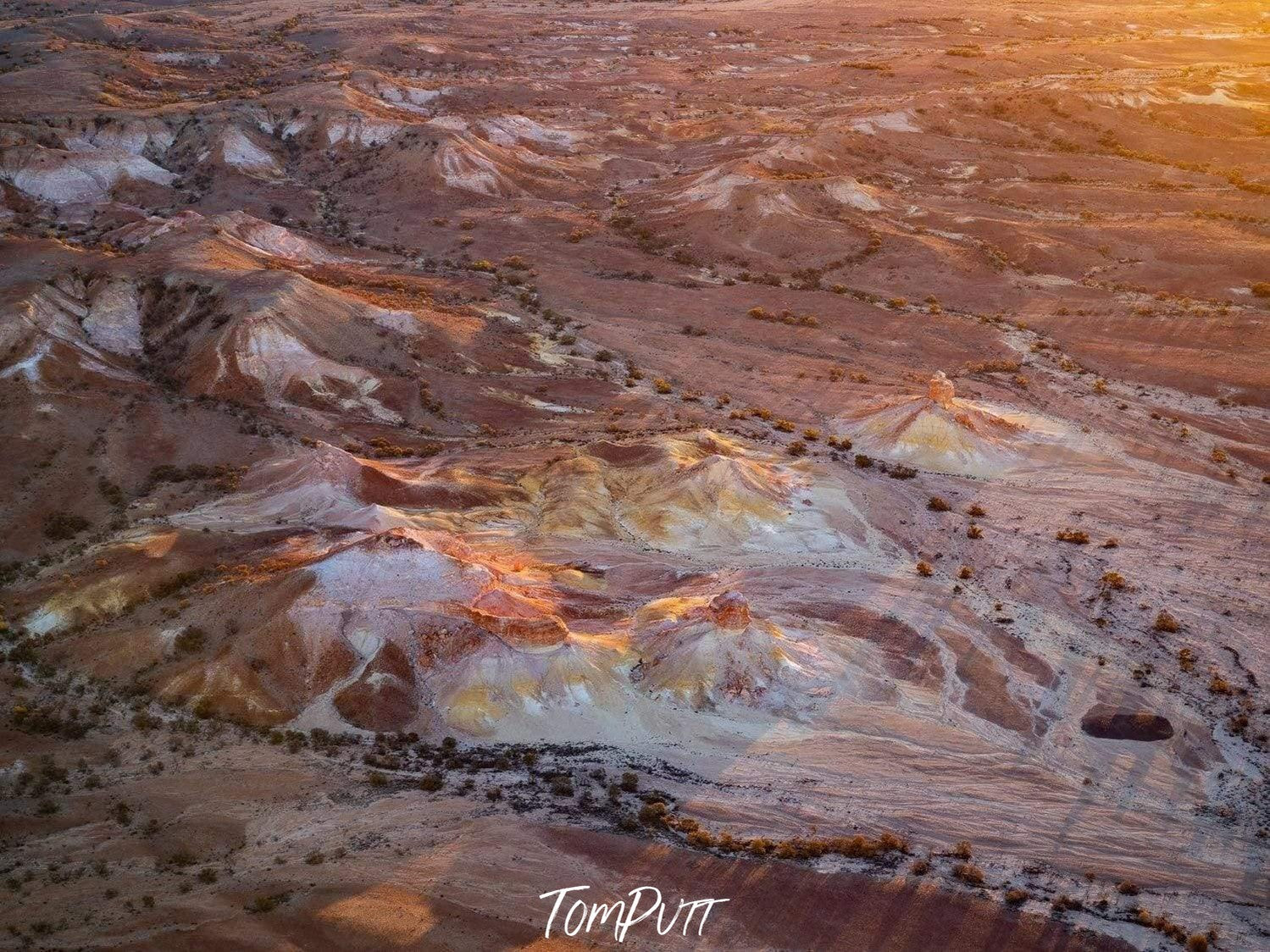 Aerial view of white and golden mounds of sand on a desert-like land, Pillars of Gold