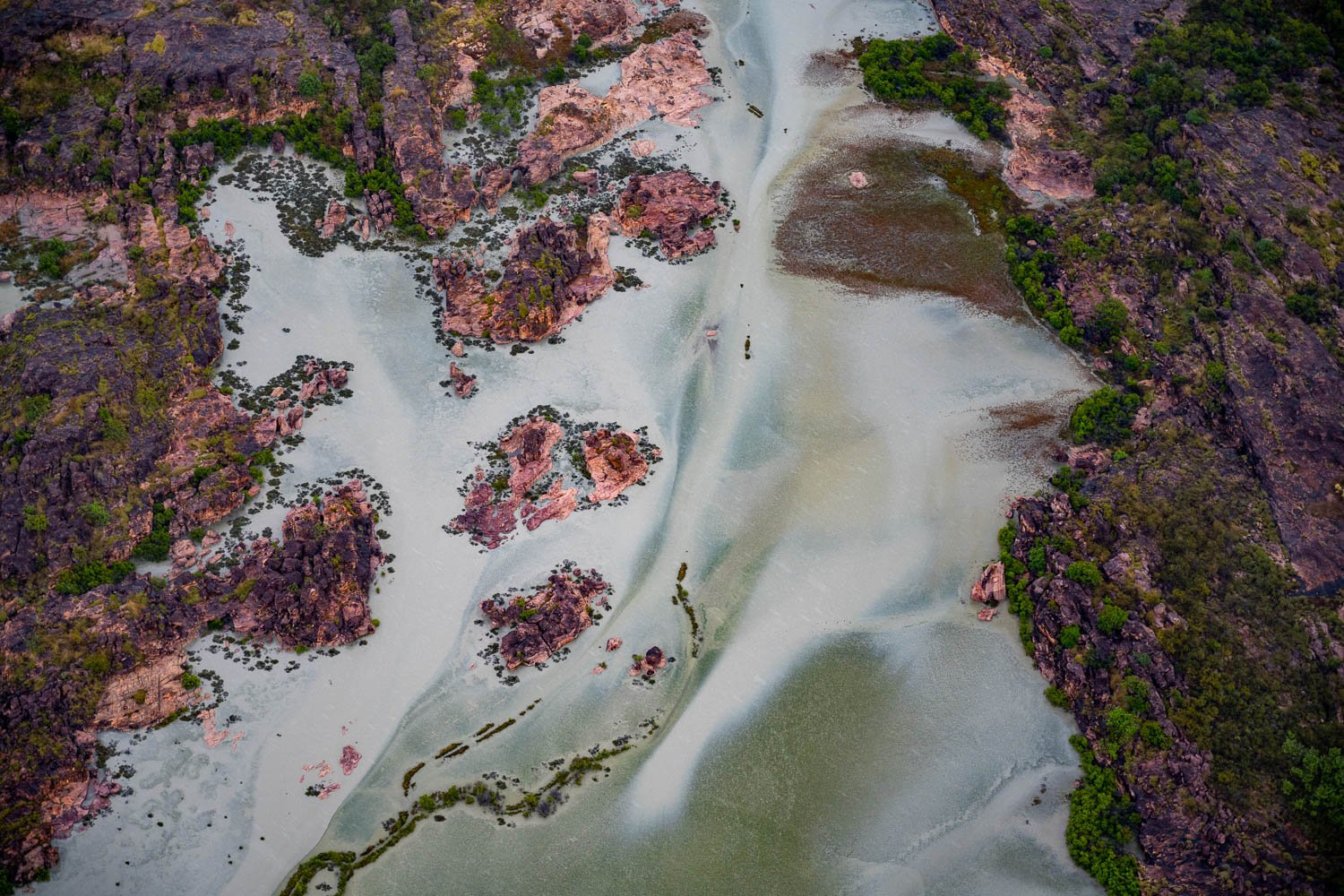 Aerial view of a milky lake with flat rocks around it, Pink Rocks, The Kimberley Coast, Western Australia