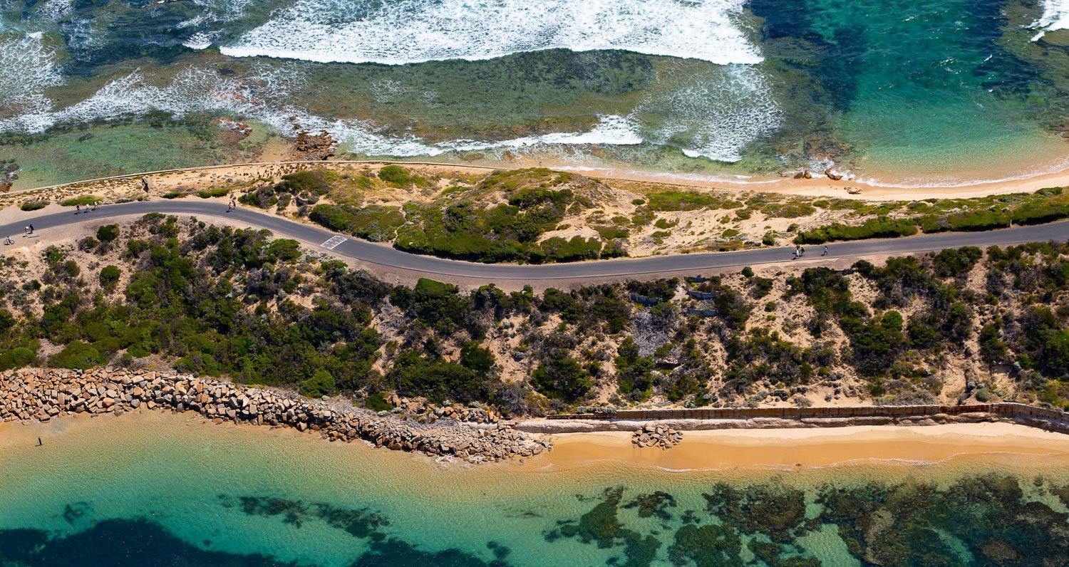 Aerial view of a sea corner with a lot of greenery and two road lines, Point Nepean National Park - Mornington Peninsula VIC
