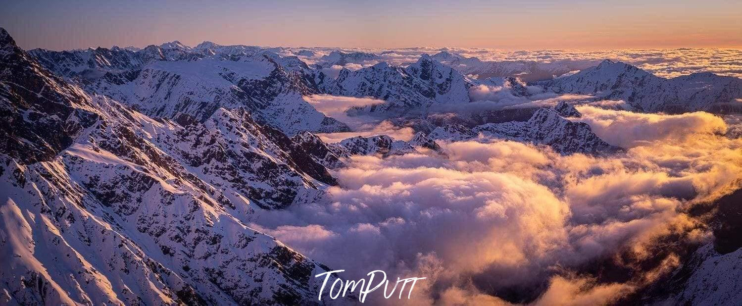 Aerial view of a snow-covered hill area with clouds over, Rising Above