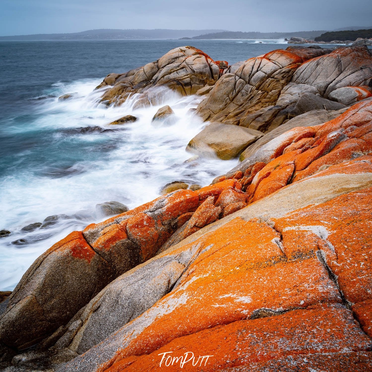 Shiny orange mountains walls with a bubbling seashore, Rocky Shoreline, Bay of Fires