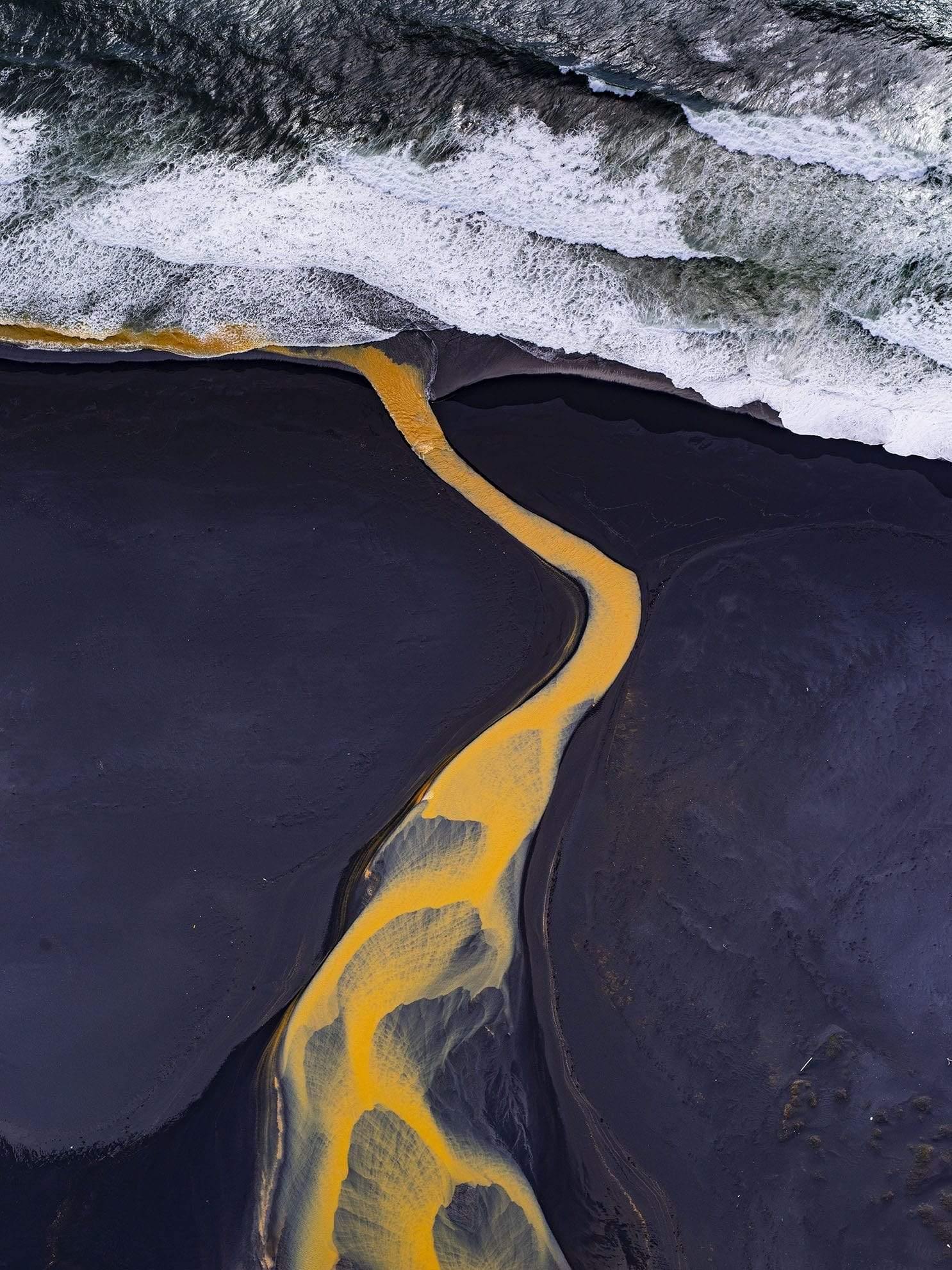 The yellow curvy line on a black surface following the sea below, Rustic Waters