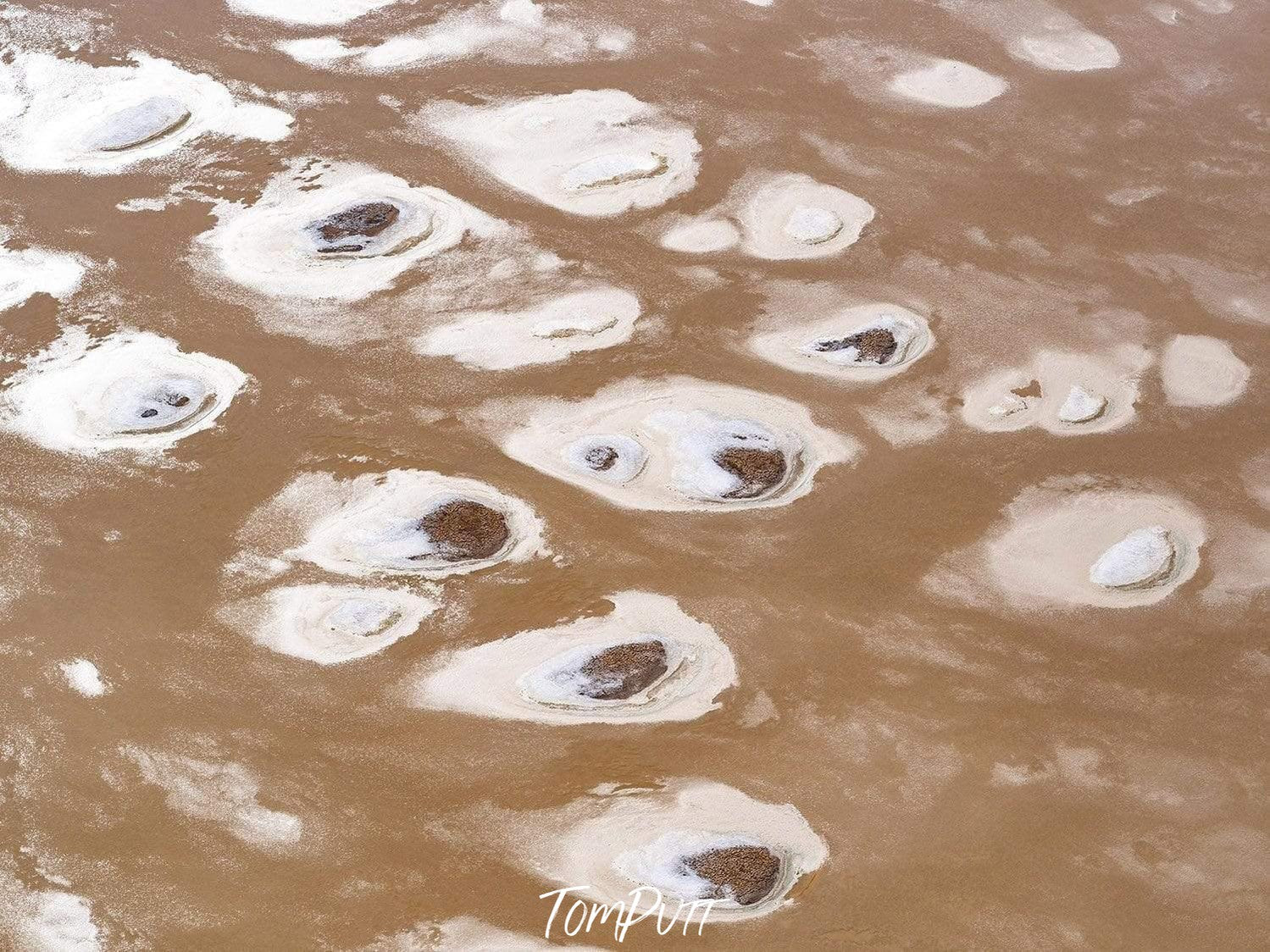 Frying egg-like texture on a beach with some water, Scattered Pebbles