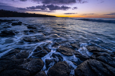 Beach with the stony surface with the flowing waves of water on the stones, and the sunset behind, Shoreham Foreshore - Mornington Peninsula VIC