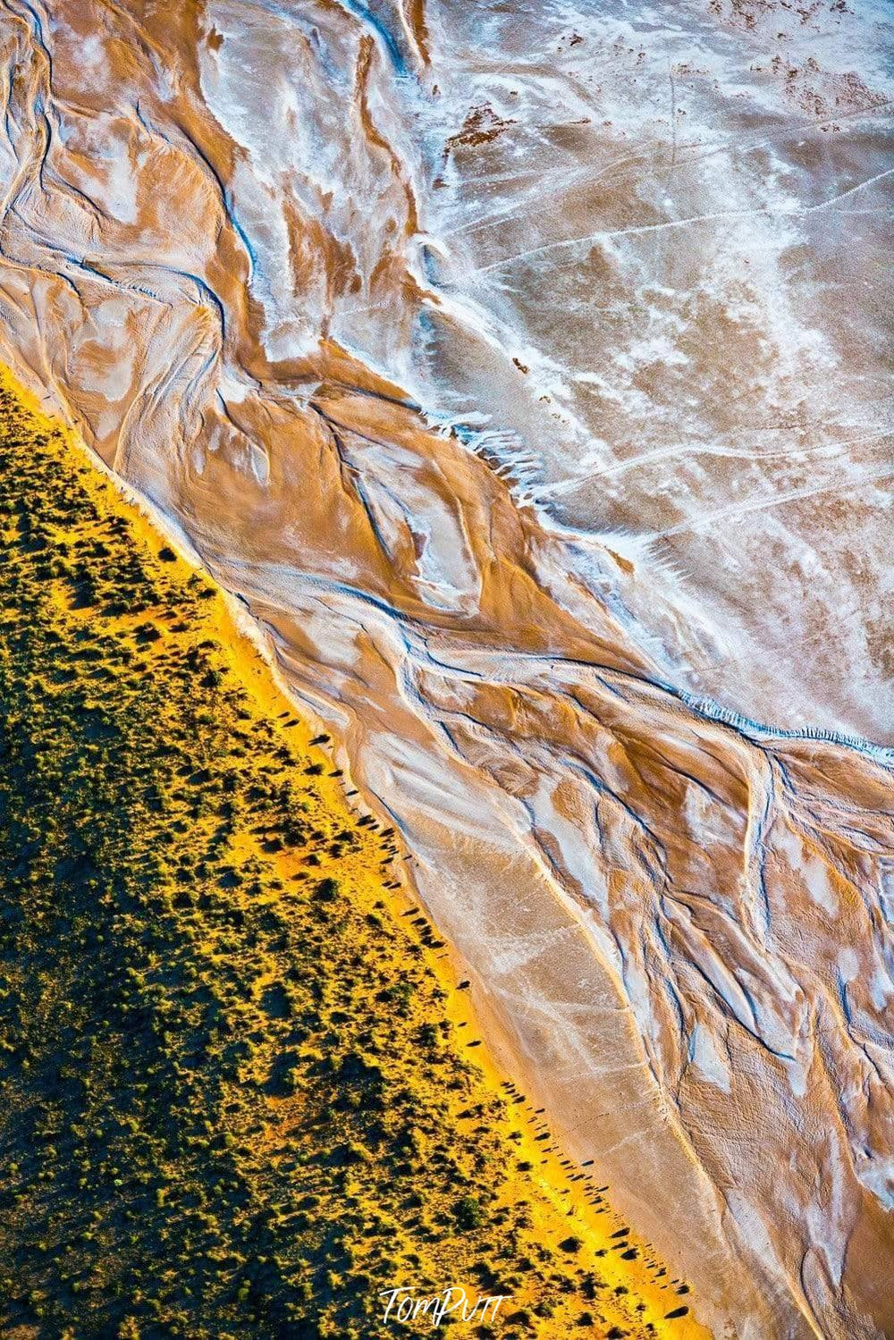 Massive bubbling waves of water on the beach with a green mountain line above, Shoreline