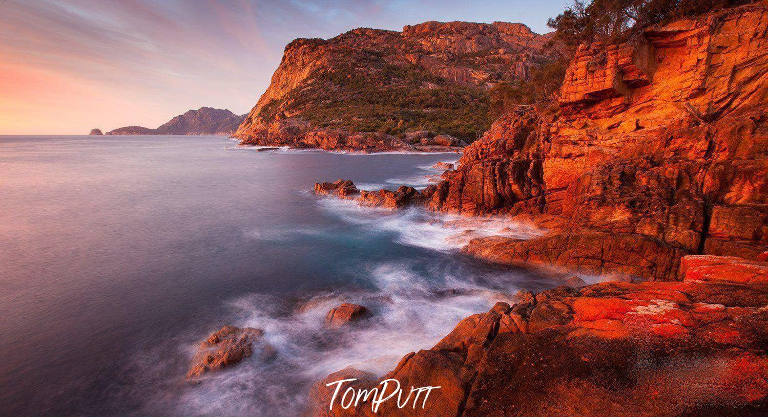 Giant orange mountain walls with a seashore below, Sleepy Bay Sunrise - Freycinet TAS