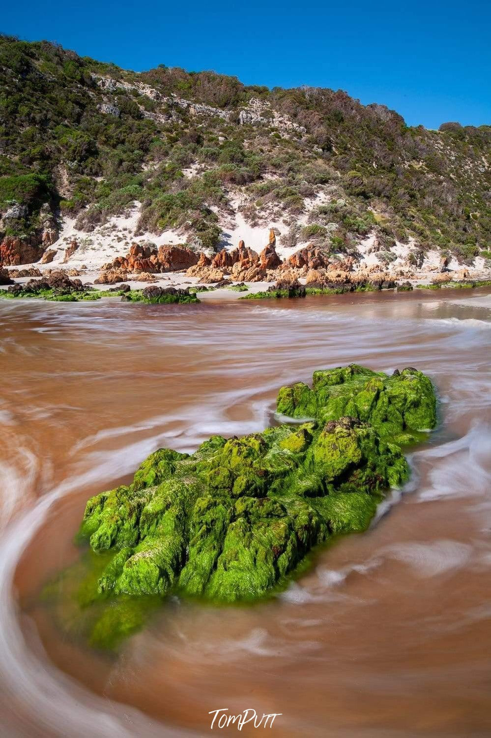 A thick curvy stone under the lake covered fully with fresh green bushes and grass, Snelling Beach Rocks - Kangaroo Island SA