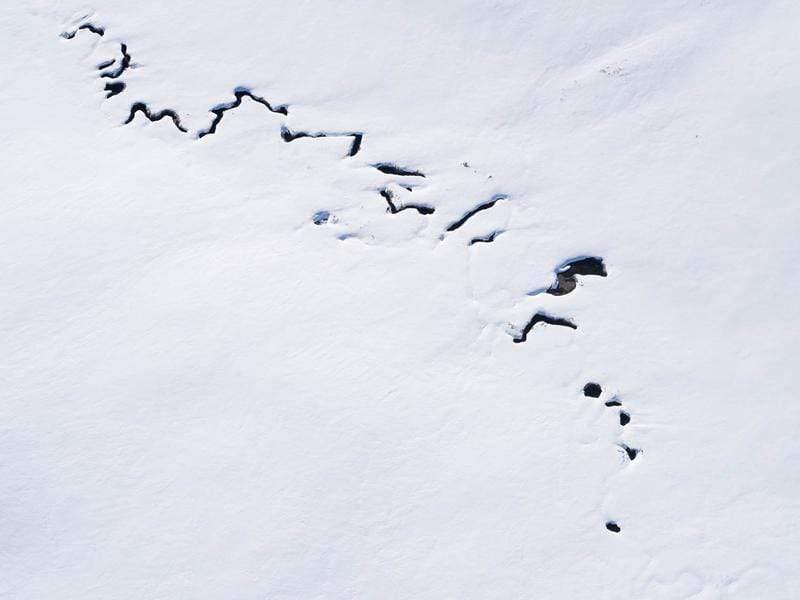 Aerial view of a snow-covered land with a cracky line, Snow Creek - Snowy Mountains NSW