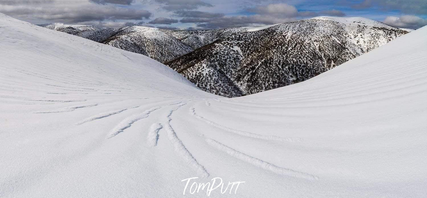 Lines on a snow-covered land with giant mountains behind, Snow Lines