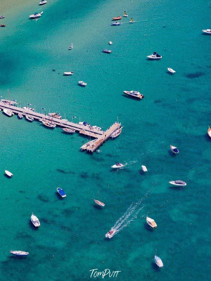 Aerial view of a sea with a wooden bridge over and some boats floating over, Sorrento Couta Boat Club Jetty - Mornington Peninsula VIC