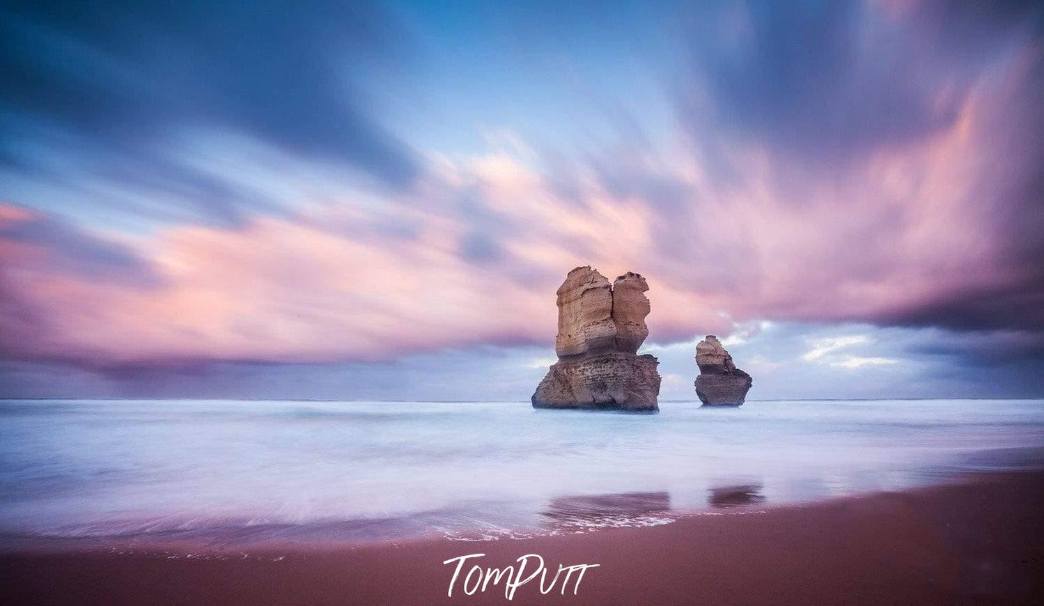 A standing couple of giant Stones with lilac-colored sky and shadow in the water, Standing Strong - Great Ocean Road VIC