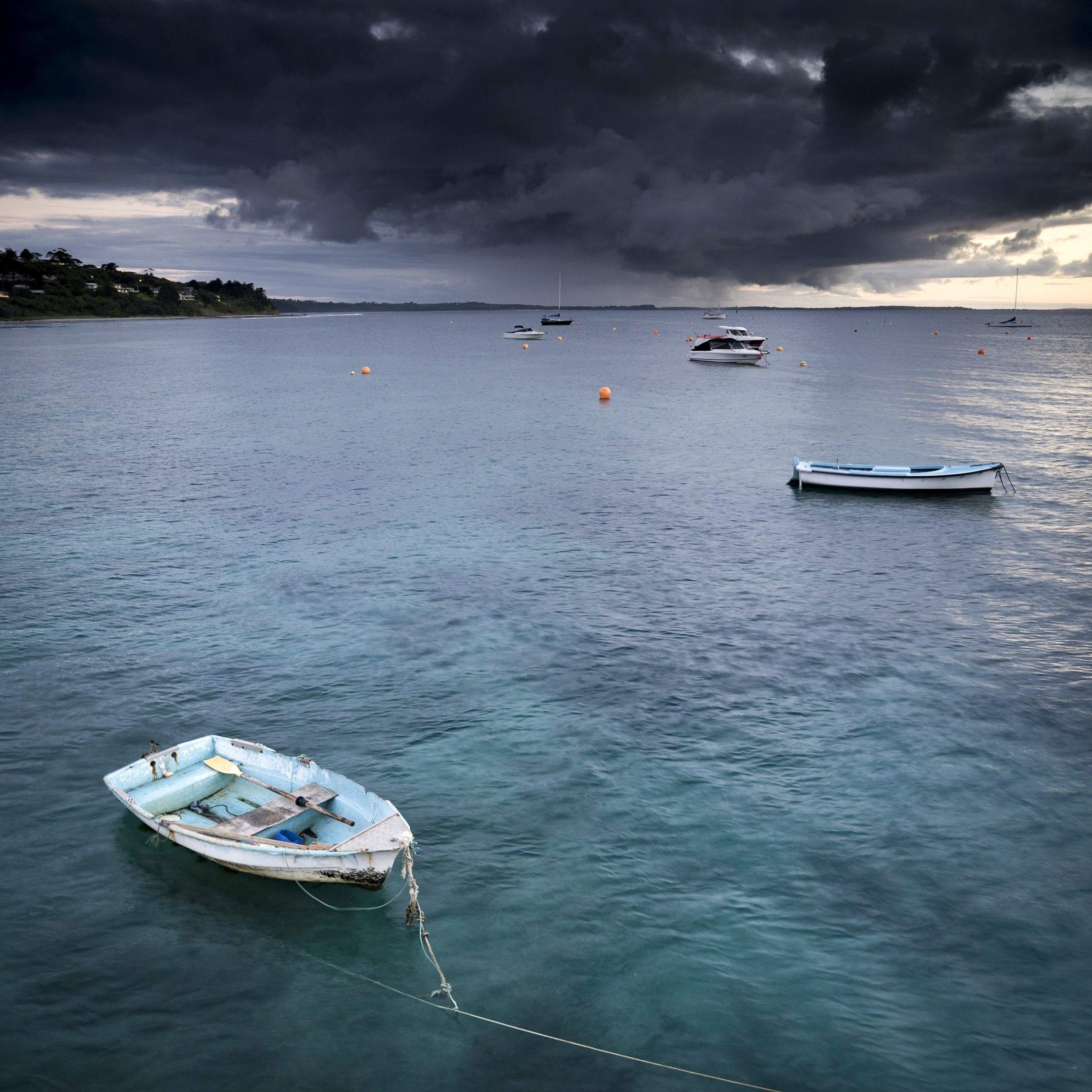 Dark clouds over a lake with some boats floating, Stormy Skies, Flinders - Mornington Peninsula VIC