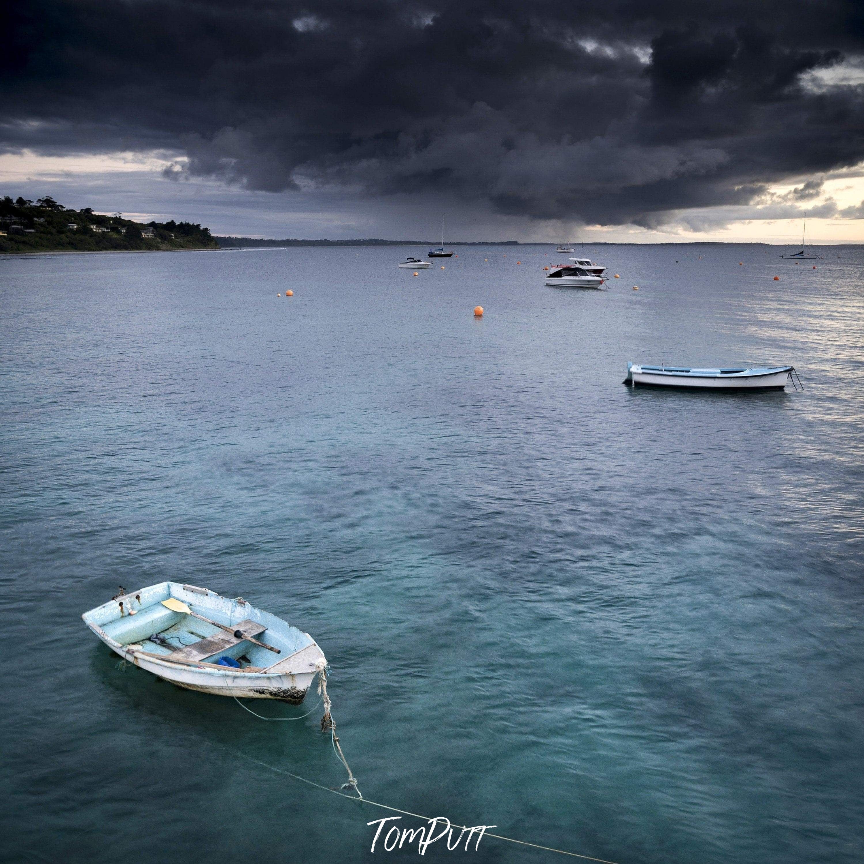 Dark clouds over a lake with some boats floating, Stormy Skies, Flinders - Mornington Peninsula VIC