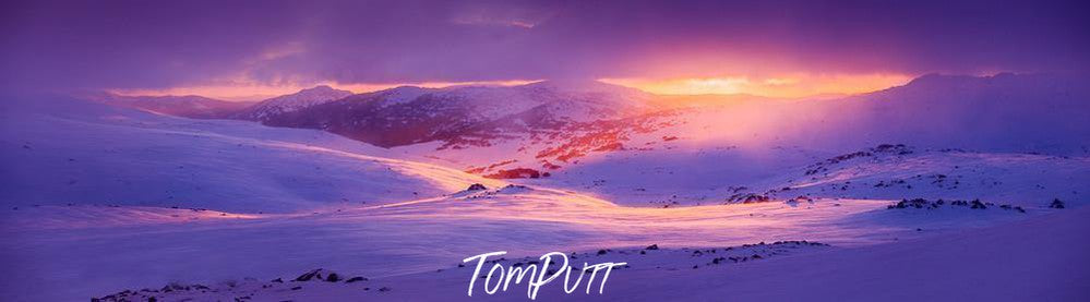 A snowy hill area fully covered under the snow with snow mounds with a beautiful scene of the rising sun spreading sunlight in the area, Charlotte Dawn New South Wales