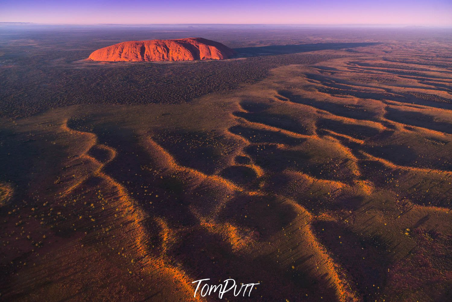 A giant texture of mound waves in the desert, Sunrise over Uluru from the air - Northern Territory