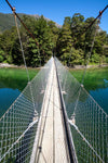 A bridge over the water with nested steel side walls, Swing Bridge across the Clinton River, Milford Track - New Zealand