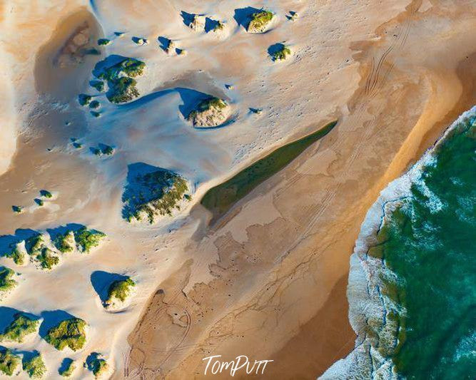 Aerial view of a sea corner with some green small mounds of grass, Tarkine Coast