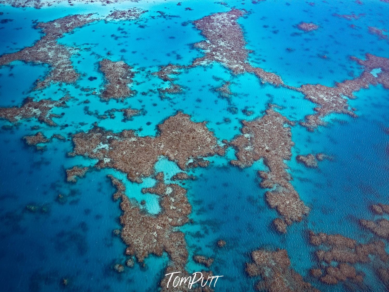 Aerial view of shiny blue lake with a lot of small stony islands, The Great Barrier Reef from above, Far North Queensland