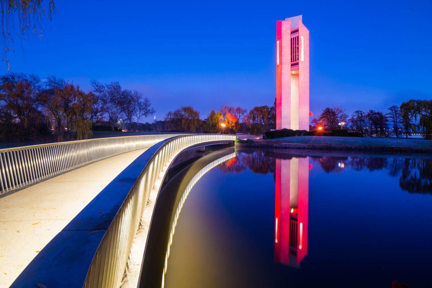 A beautiful pink-shaded white building on a lake corner, The Night Carillon - Lake Burley Griffin AC