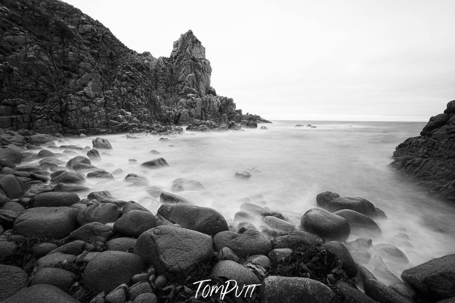 A beach with a lot of rounded stones and some standing sculpture of stones behind, The Pinnacles 6, Phillip Island