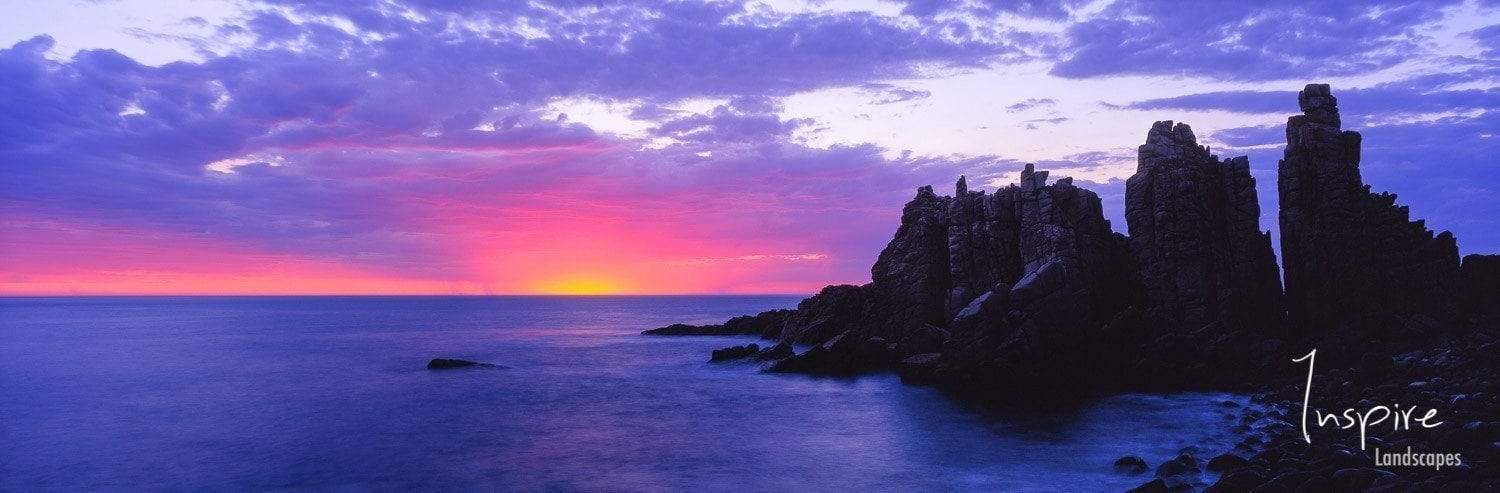 Purple sunset effect on the lake and some standing sculpture of stones behind, The Pinnacles Sunset - Cape Woolamai VIC