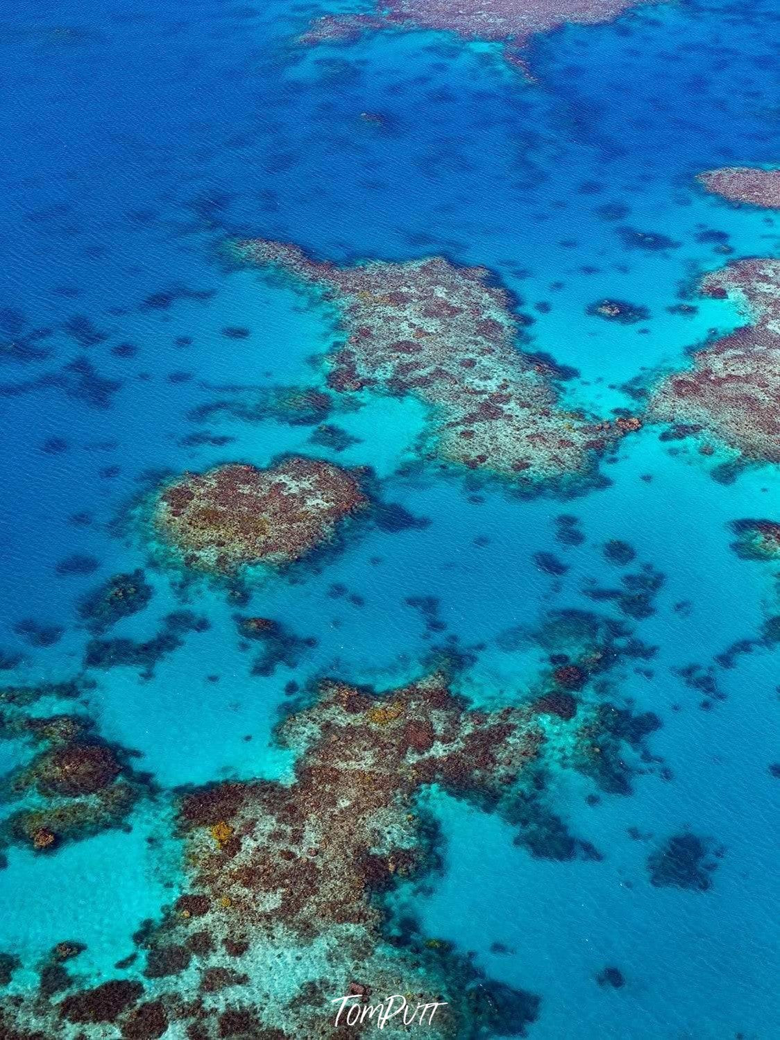 Aerial view of a blue lake with a lot of stony islands over, The Reef