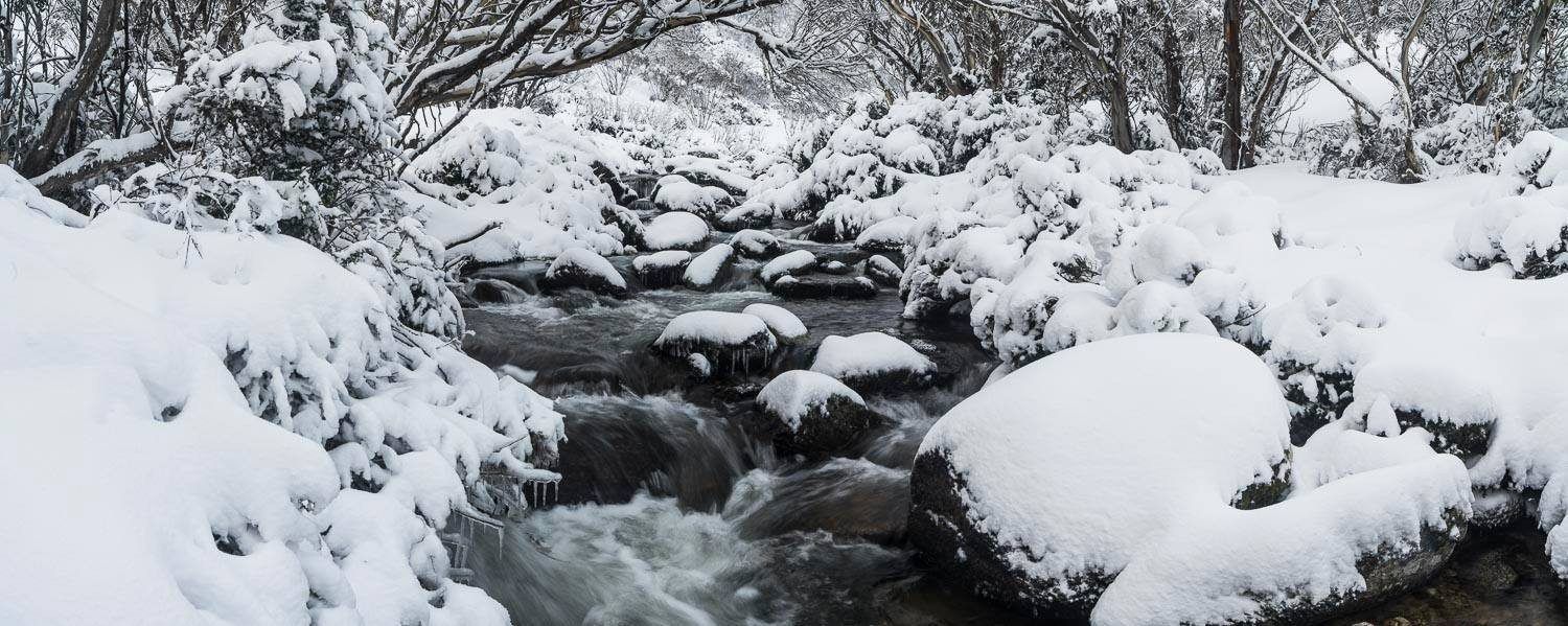 A watercourse with a lot of stones and fresh snow on them, Thredbo River - Snowy Mountains NSW