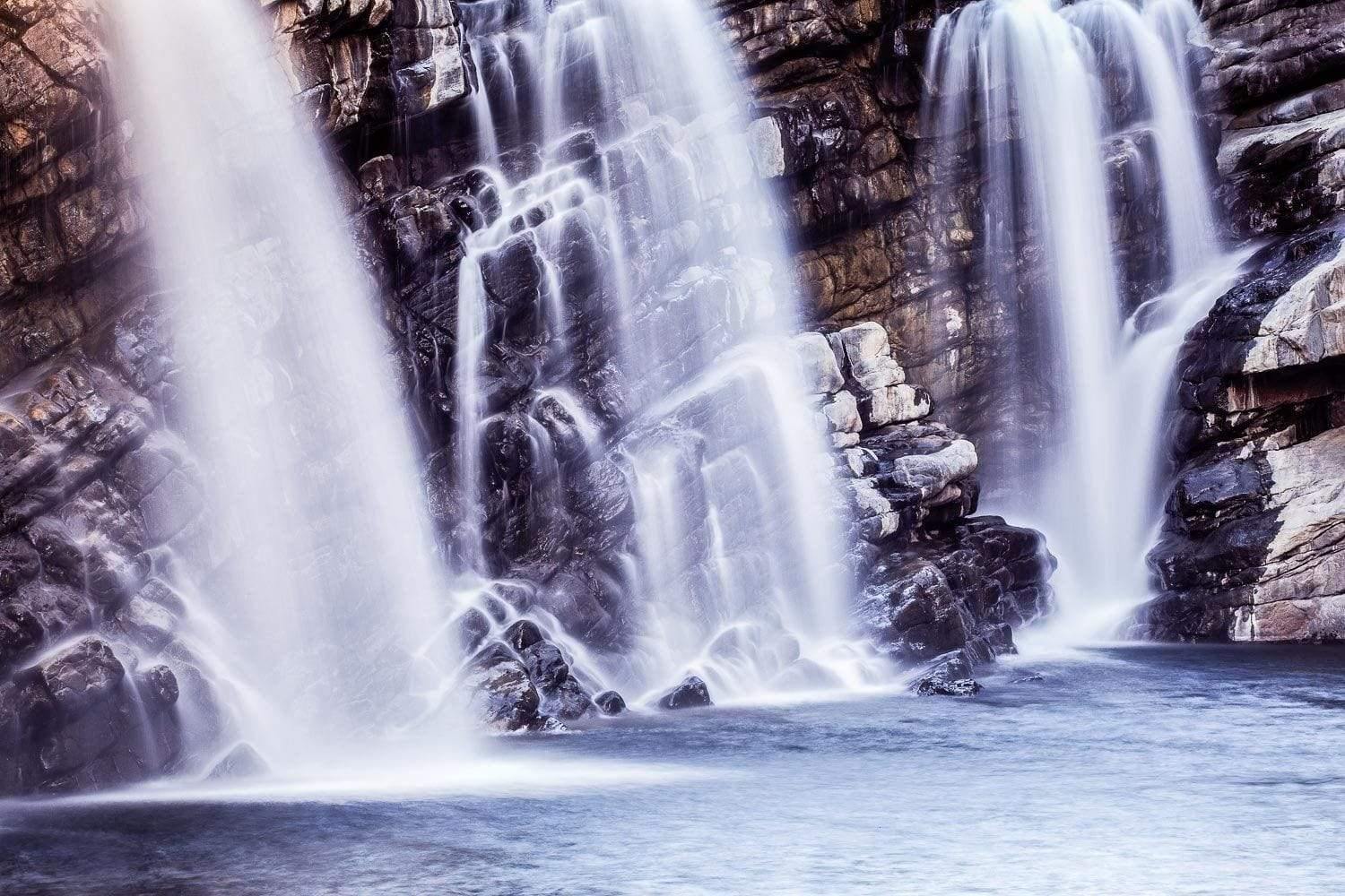 Three waterfalls from a rocky mound into a small lake, Triple Falls - The Kimberley, WA
