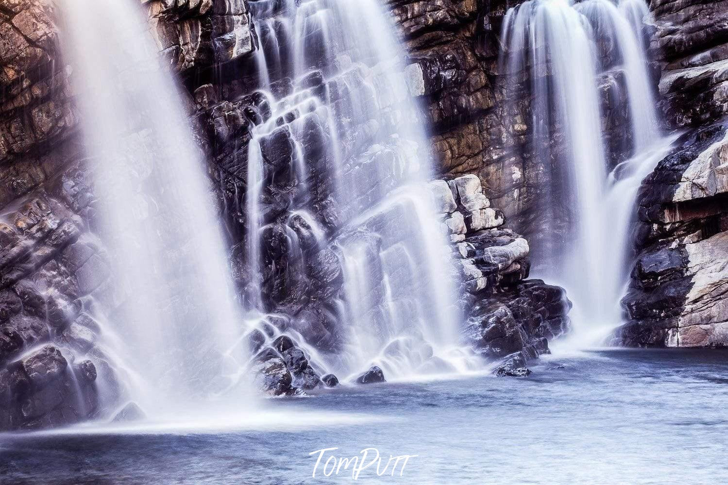 Three waterfalls from a rocky mound into a small lake, Triple Falls - The Kimberley, WA