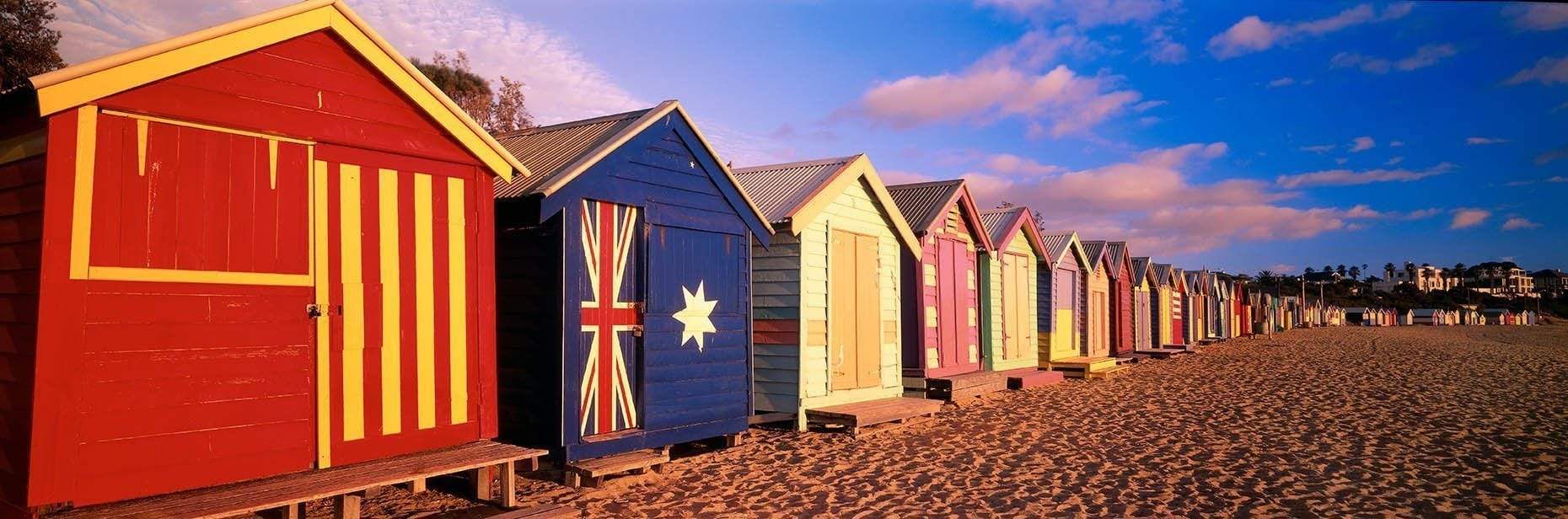 Similar shapes but different colors of huts with different flags painted on, True Blue - Brighton VIC 