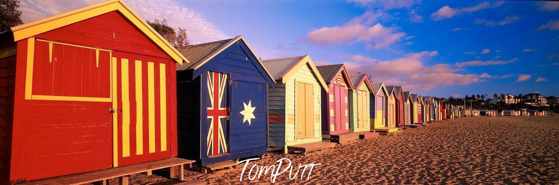 Similar shapes but different colors of huts with different flags painted on, True Blue - Brighton VIC 