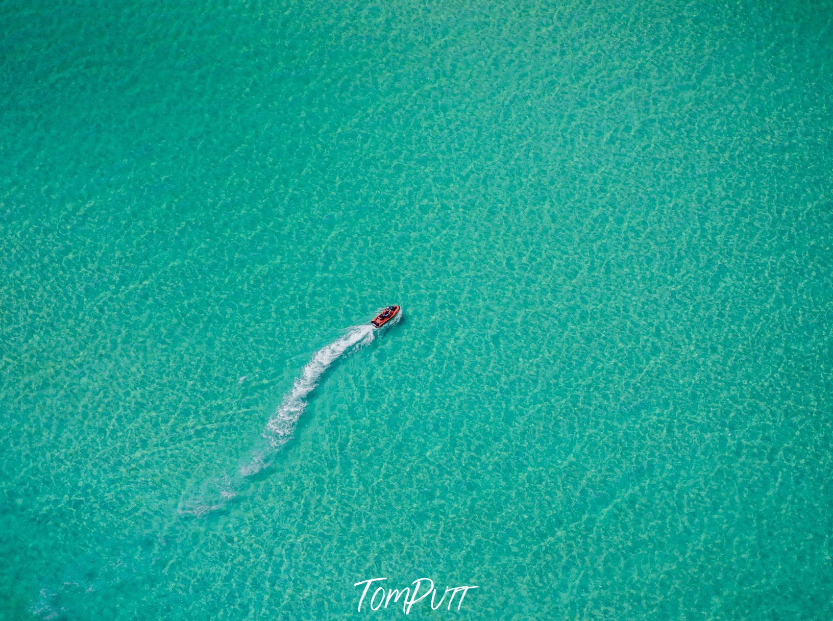 Aerial view of the ice-blue ocean with a boat passing over, Turquoise - Mornington Peninsula VIC 