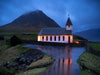 A church built beside a big black mountain with a small lake ahead, Vidareidi Church, Faroe Islands