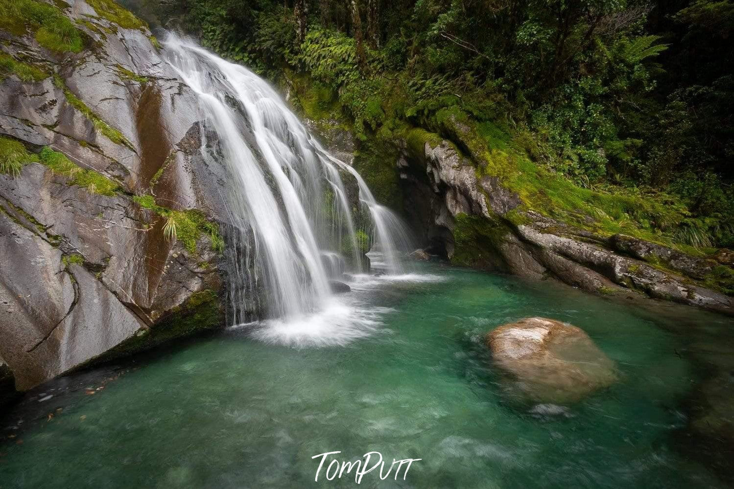 Long waterfalls from a green mound into a lake, Waterfall 2, Milford Track - New Zealand