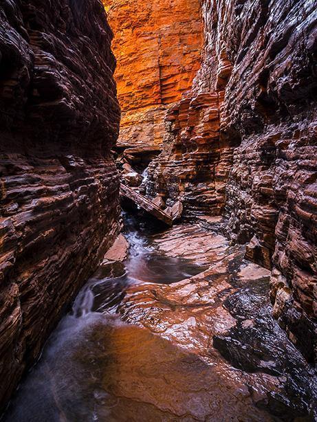 A pathway under giant rocky mountain walls of different burning shades, Weano Awakens - Karijini, The Pilbara
