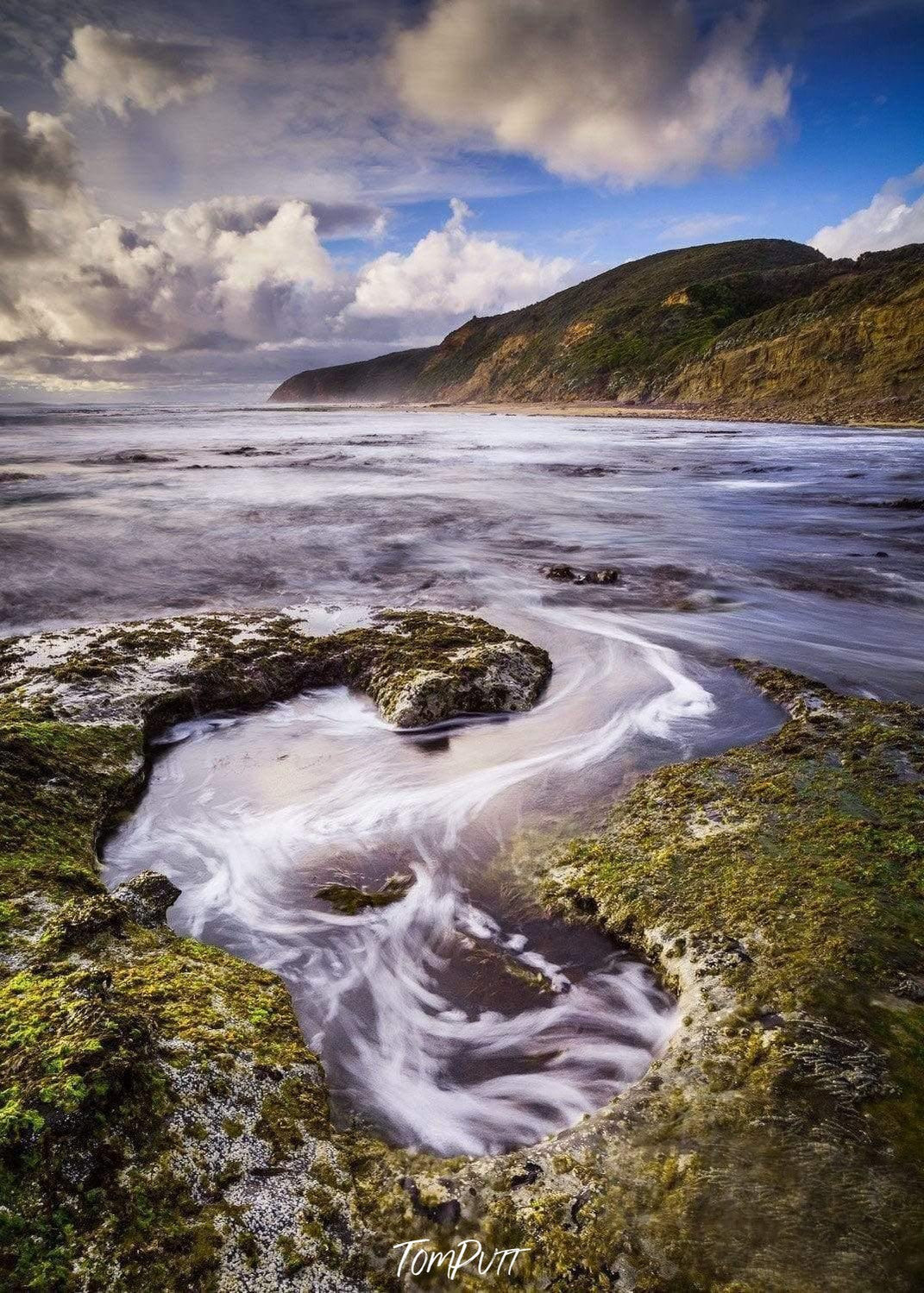 A long shot of a lake with some greeny land, and a big golden mountain behind, Whirlpool - Great Ocean Road VIC