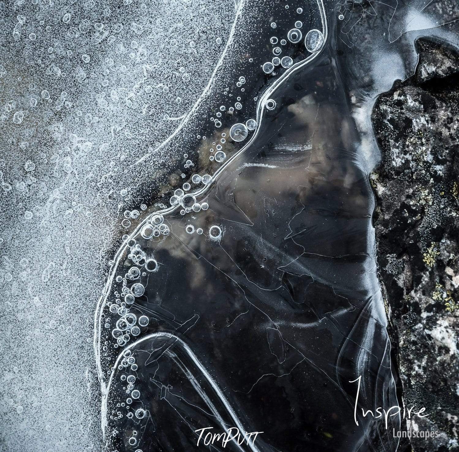 Dark aerial shot of a frozen lake with many shades of black, Winter Ice - Cradle Mountain TAS  