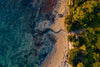 Aerial view of a green seashore with some sandy surface covered with thick plants and trees, Zig Zag from above, Mornington Peninsula, VIC